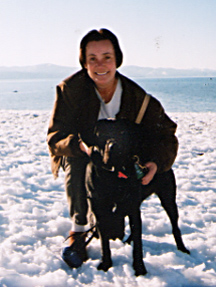 Bev and Cynthia squating in packed snow on a sunny day.